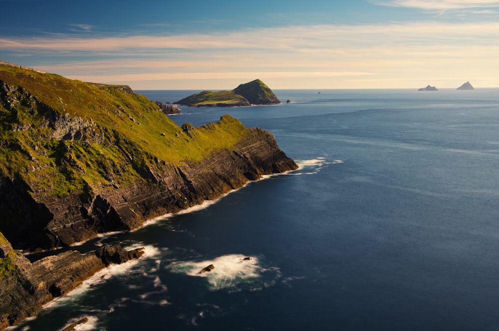 a large body of water surrounded by a lush green hillside