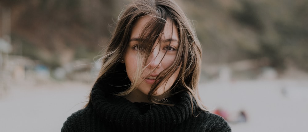 a woman with her hair blowing in the wind