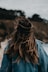 a woman with long hair walking on the beach