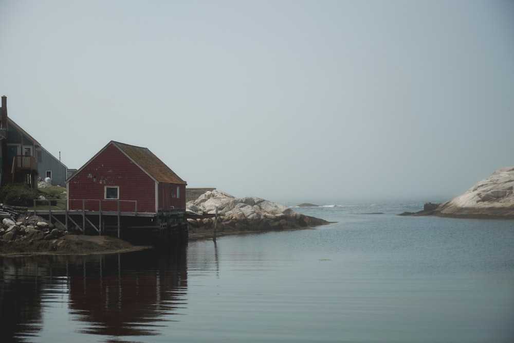 a red house sitting next to a body of water