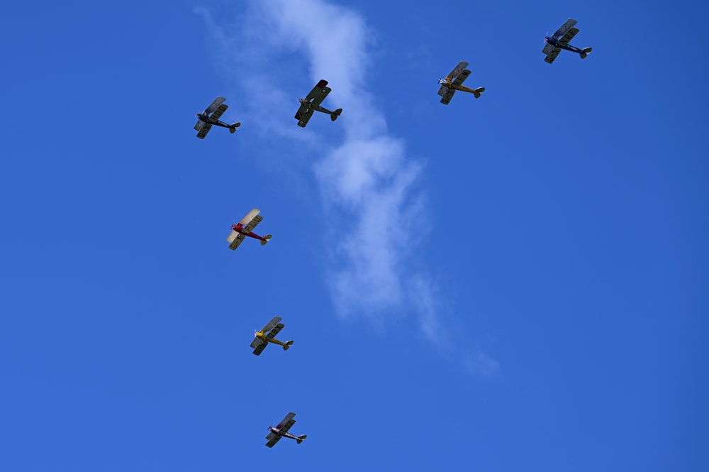 a group of planes flying through a blue sky