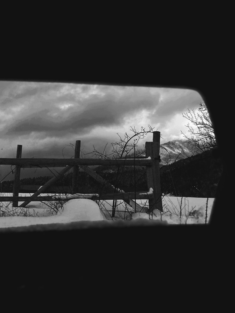 a black and white photo of a wooden fence