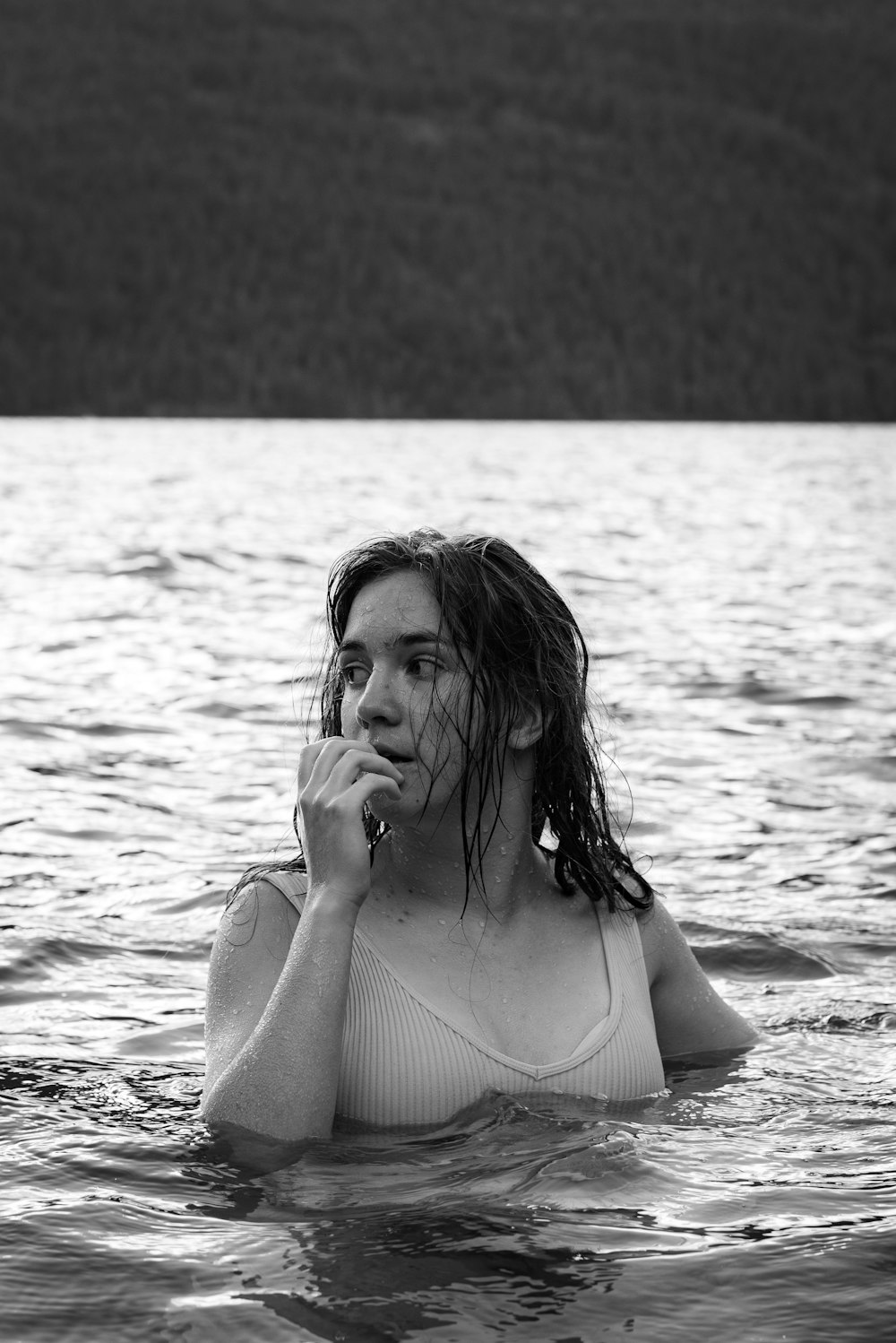 a woman in a body of water with a cigarette in her mouth