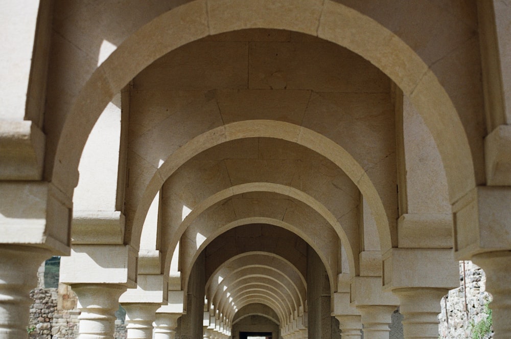a long hallway with arches and benches on both sides