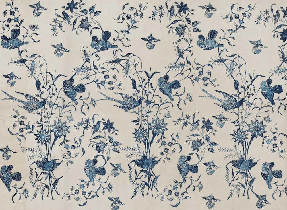a blue and white wallpaper with birds and flowers