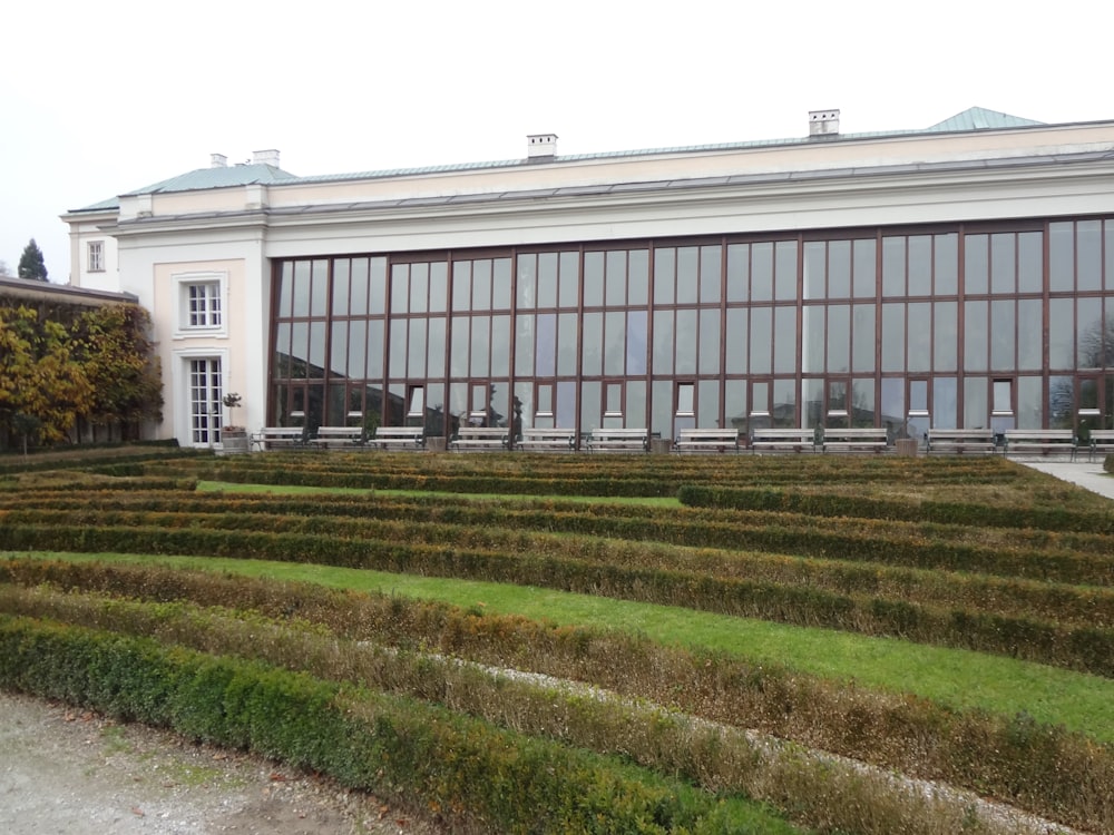 a very large building with a very long row of hedges in front of it
