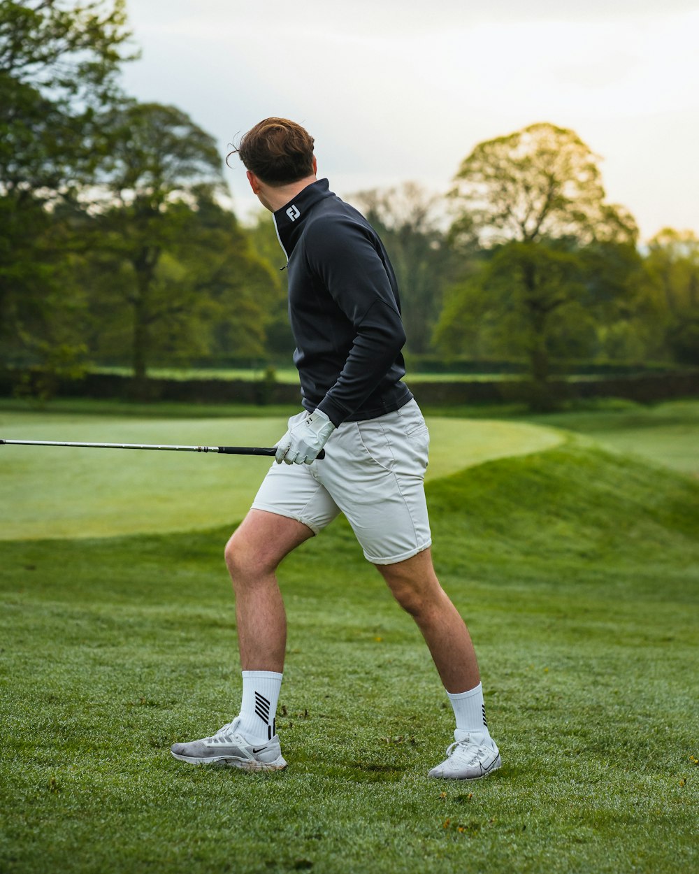 a man holding a golf club on a golf course