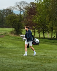 a man walking across a lush green field