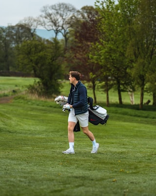 a man walking across a lush green field