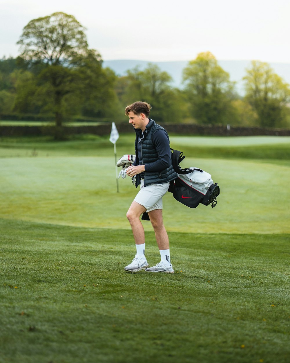 a man walking across a lush green golf field