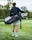 Image of a woman walking on a golf course carrying a sleek golf bag