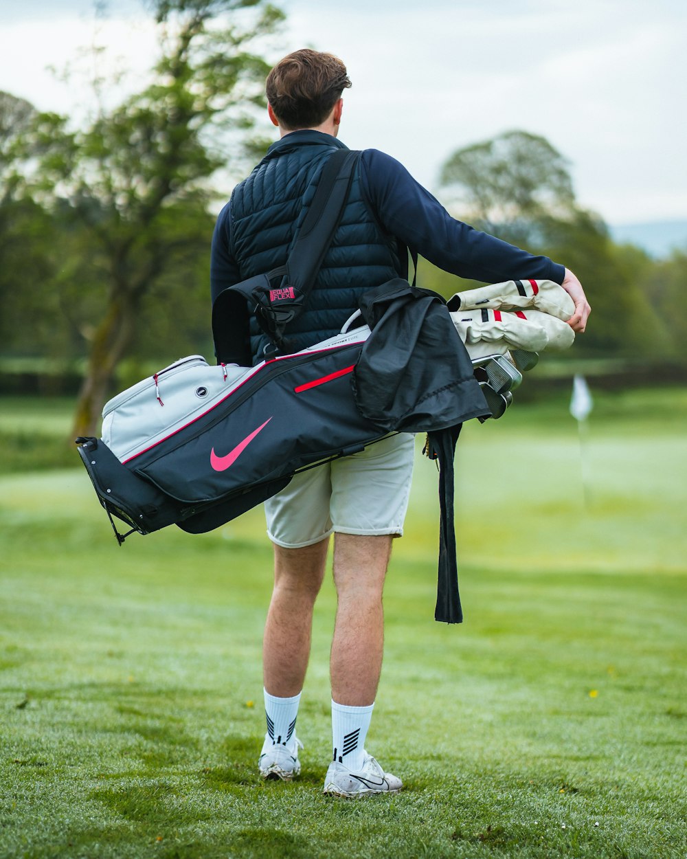 a man carrying a golf bag on a golf course