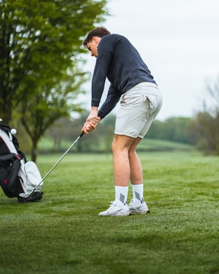 A casual golf outfit laid out on a rustic wooden table, ready for the day.