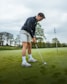 a man putting a putt on a golf course