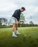 a man putting a putt on a golf course