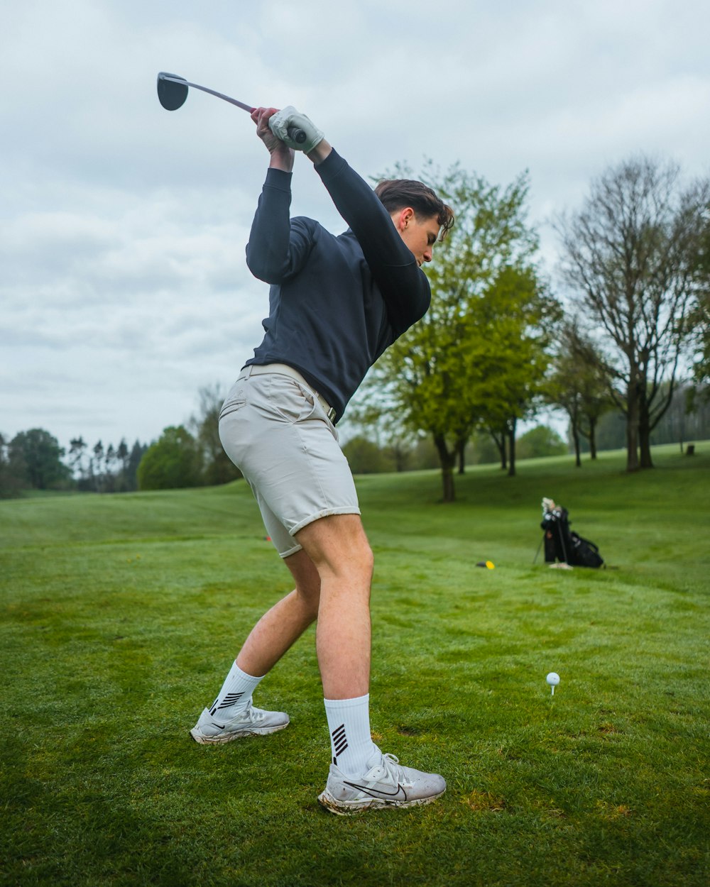 a man swinging a golf club on a golf course