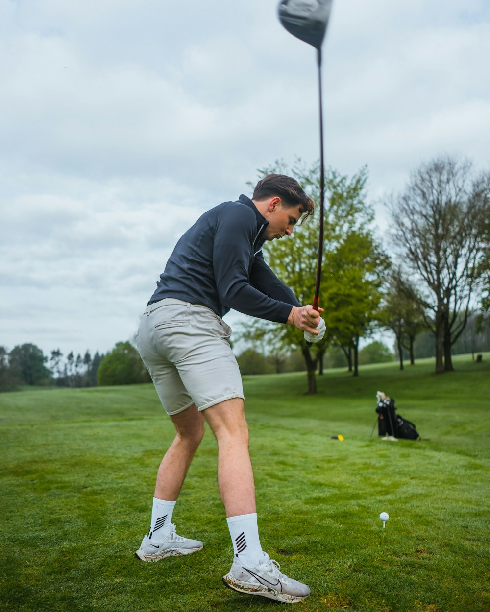 a man playing golf on a cloudy day