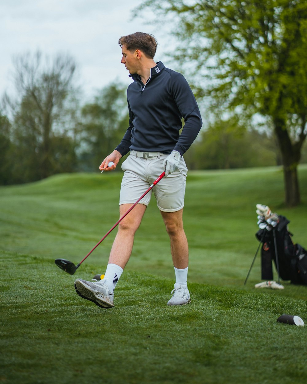 a man holding a golf club on a golf course