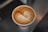 Close-up of a freshly brewed coffee cup with a delicate latte art heart.