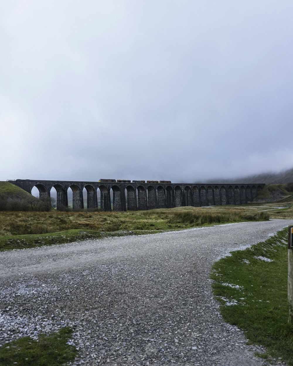 an old train bridge over a gravel road