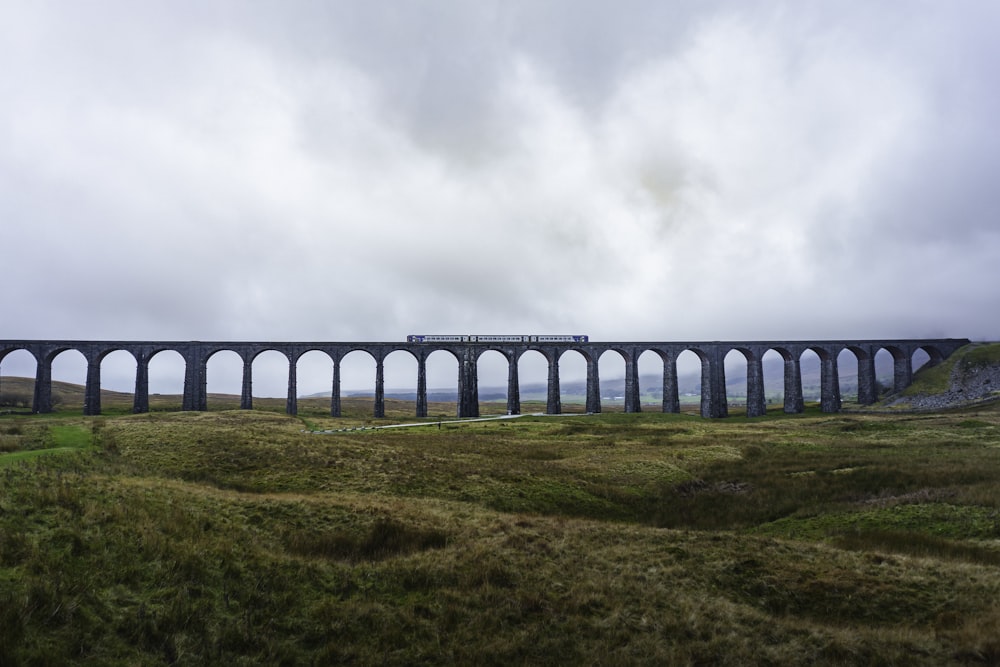 a train traveling over a bridge on a cloudy day