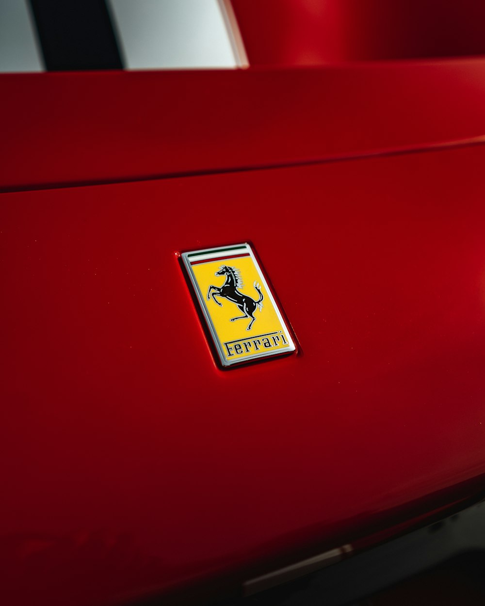 Un primo piano di uno stemma Ferrari su un'auto rossa