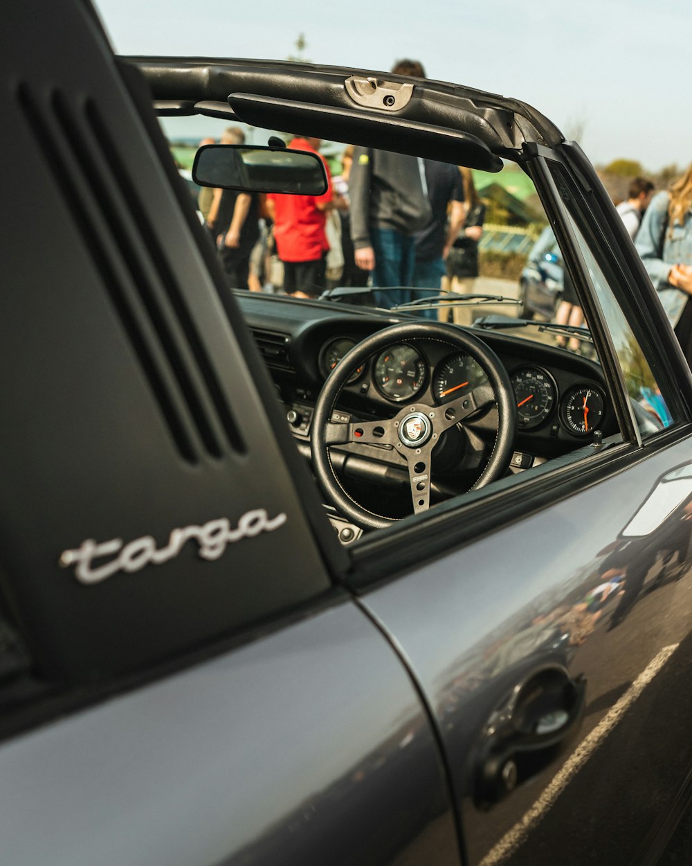 a close up of a car's dashboard with people in the background