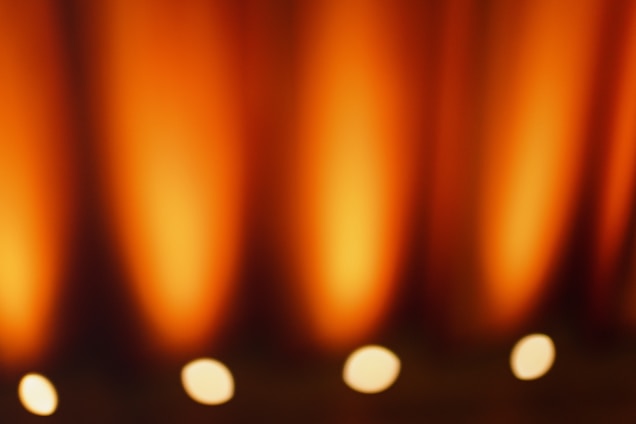 A cozy, atmospheric scene blending warm orange and gold tones with deep black shadows, evoking a fantasy book's essence.