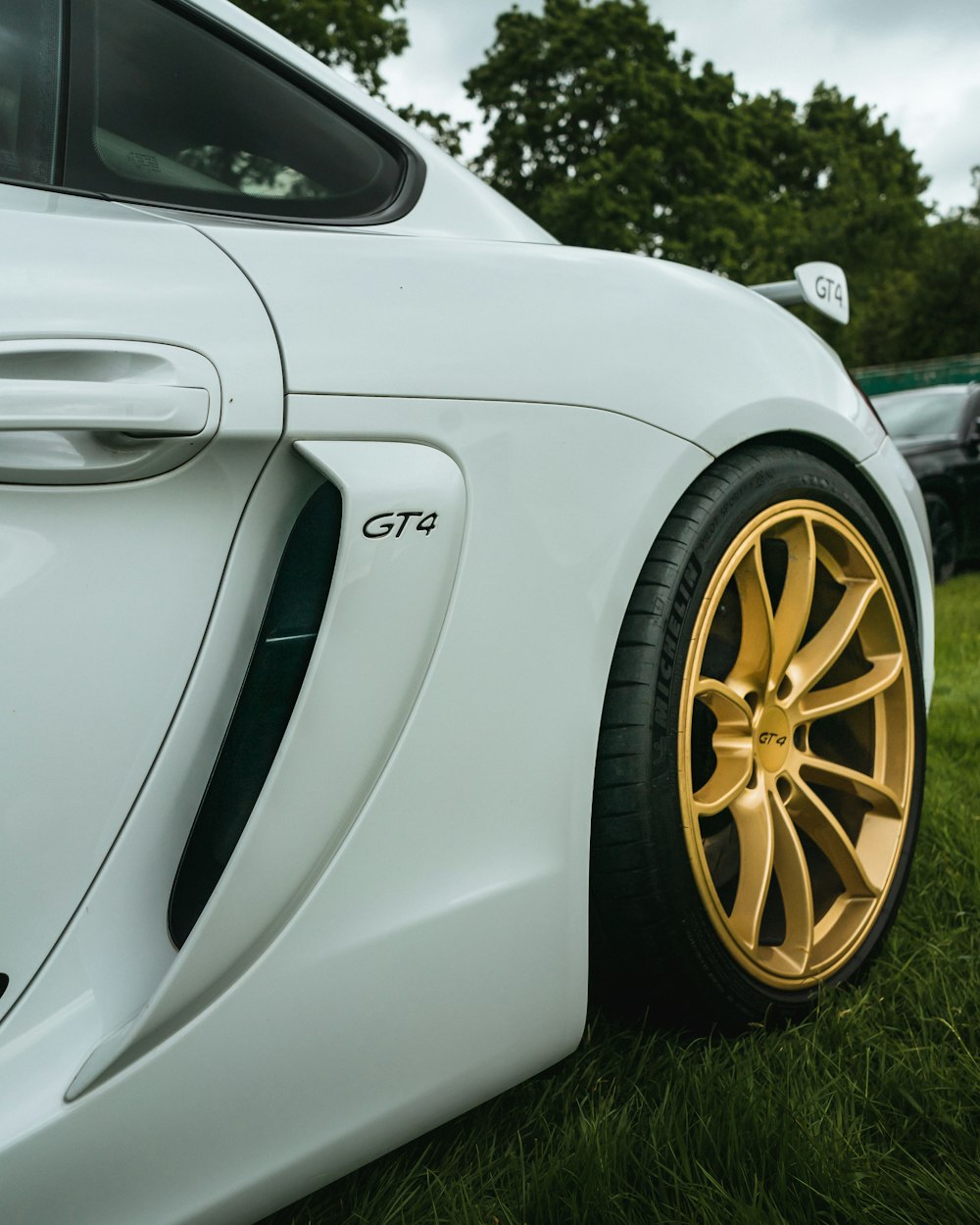 a close up of a white sports car with gold rims