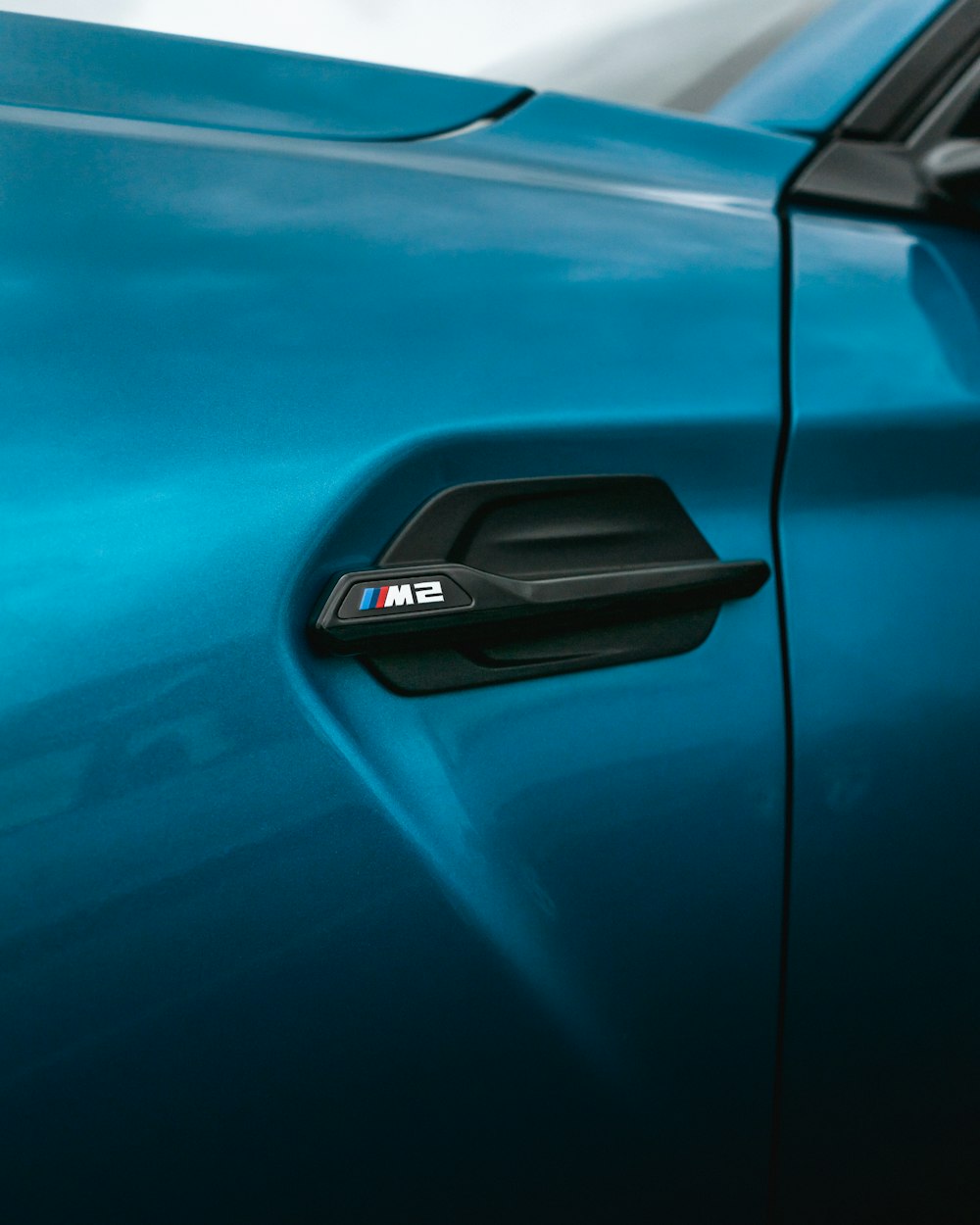 a close up of a blue bmw car door handle