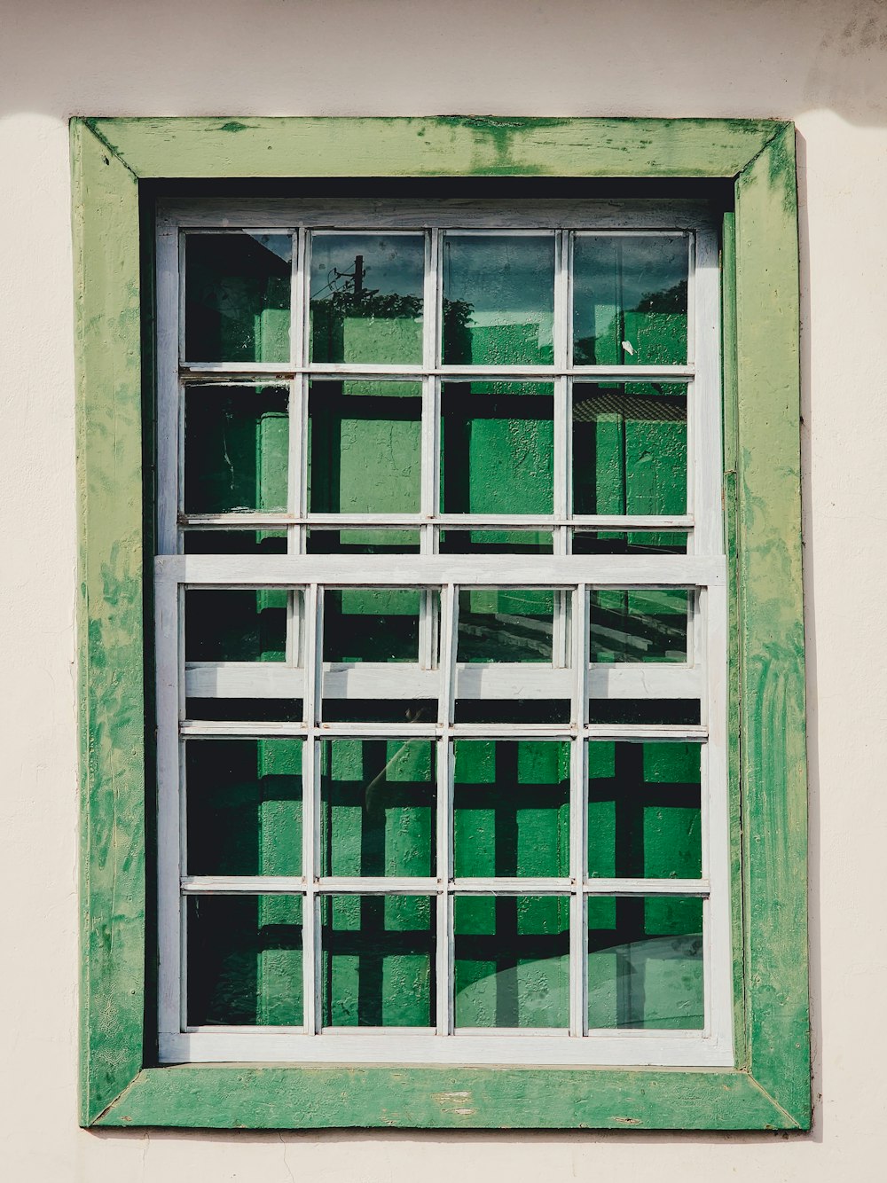 a green and white window on a white wall