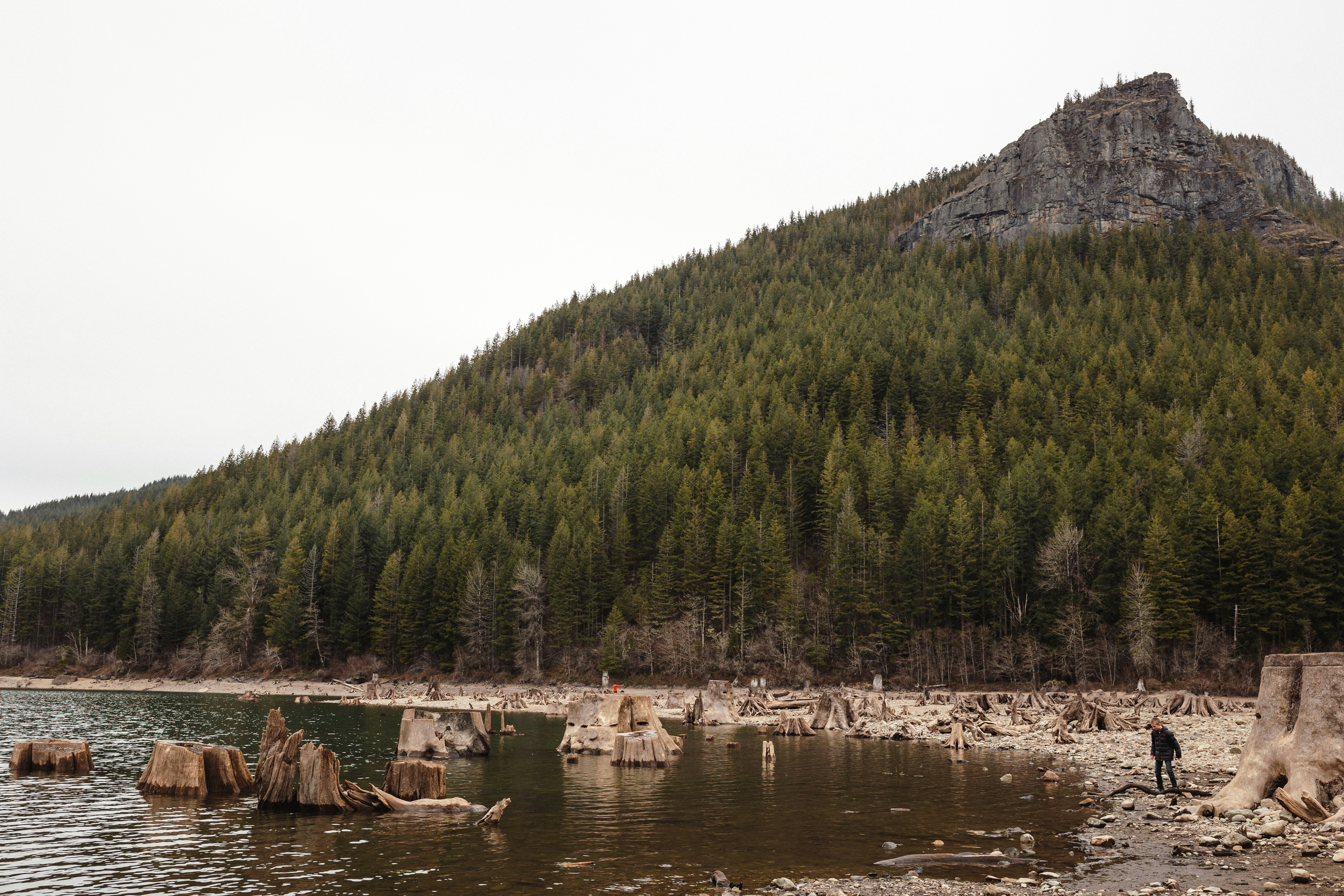 a man standing on the shore of a lake