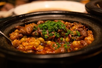 Rustic dish featuring colorful sambal and fresh vegetable accompaniments in an earthen bowl