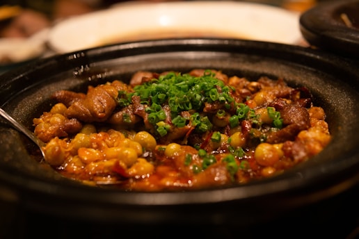 Rustic dish featuring colorful sambal and fresh vegetable accompaniments in an earthen bowl