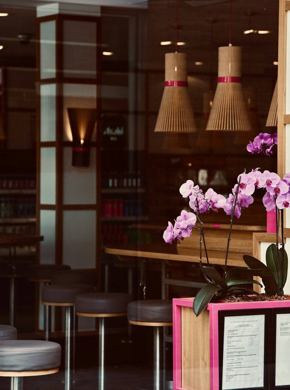 a flower pot with purple flowers on a table in a restaurant