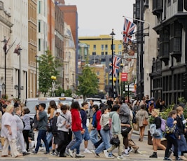 a crowd of people crossing a street in a city