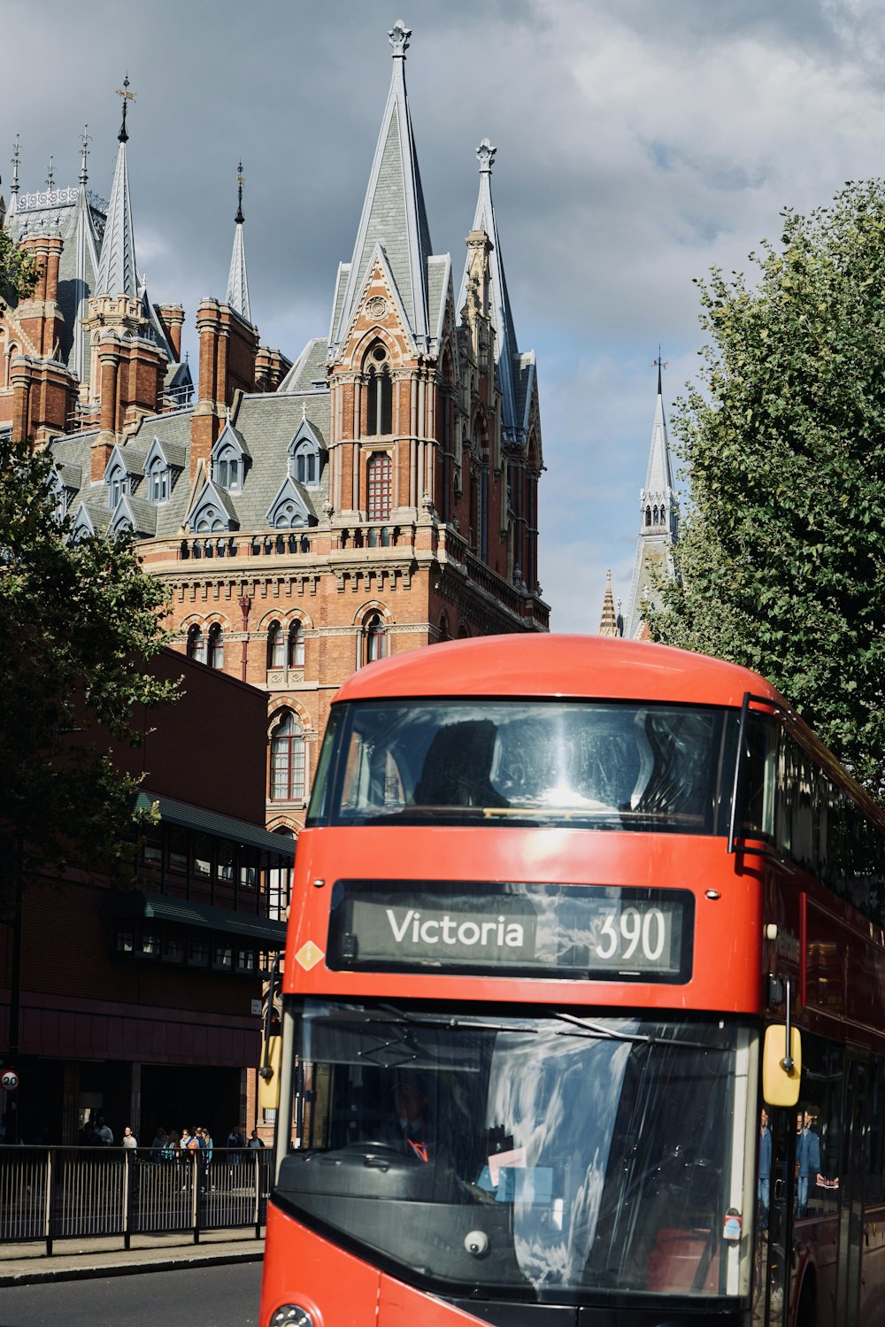 a red double decker bus driving down a street