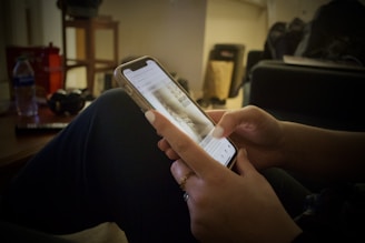 A person using a smartphone app with a calm, focused expression in a cozy home setting.