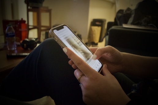A person using a smartphone in a cozy setting, focused on a quit smoking app.