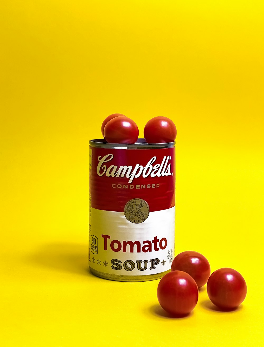 a can of tomato soup on a yellow background