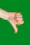 a person's hand holding a cell phone in front of a green background