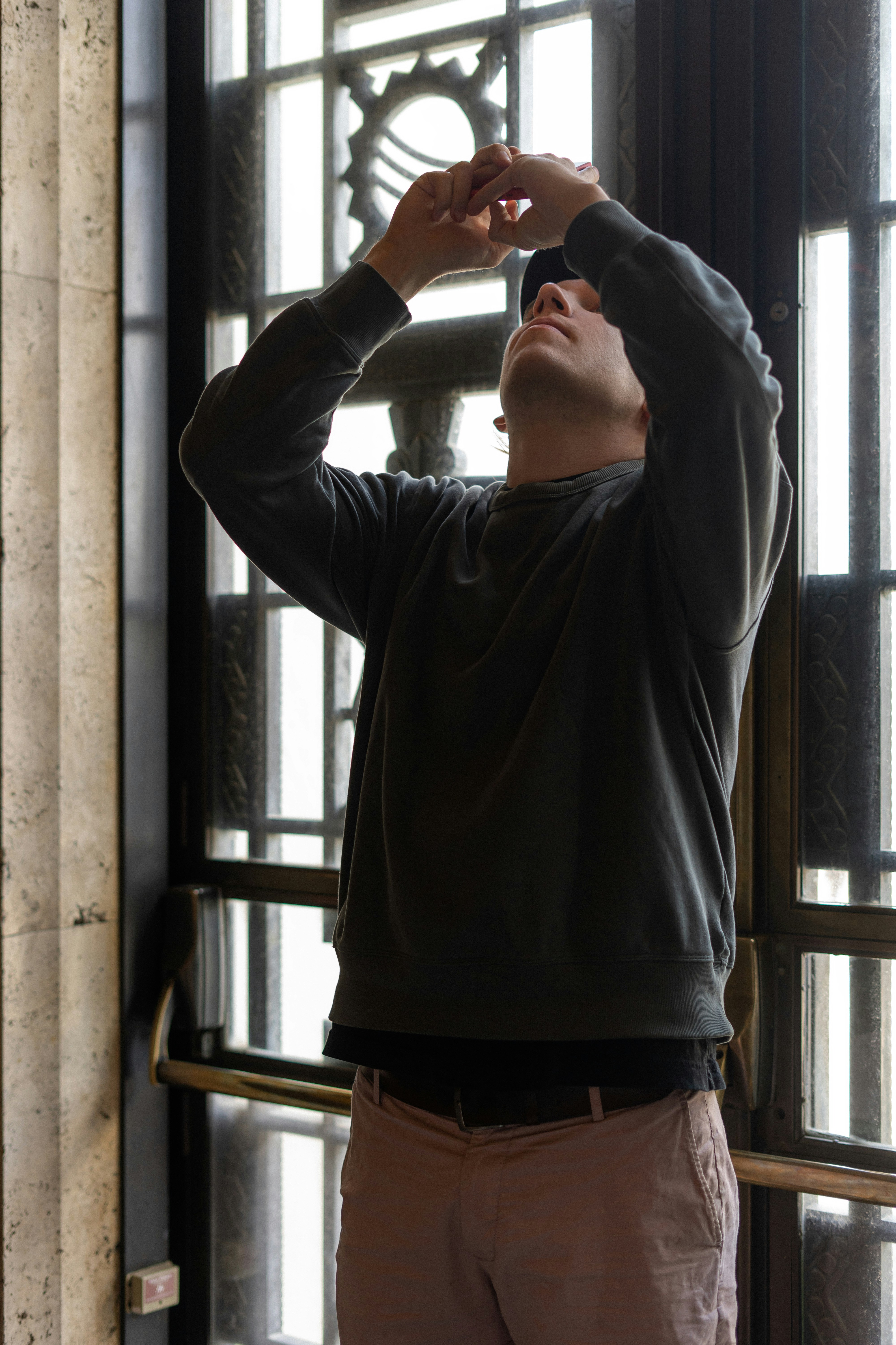a man standing in front of a window taking a picture
