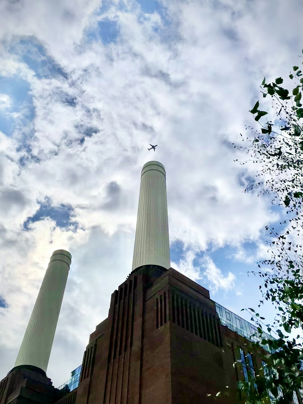 a tall tower with a plane flying over it