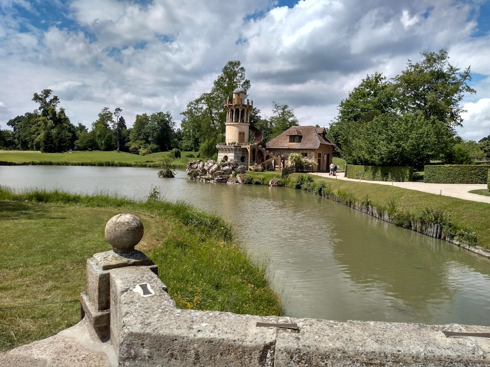 a large house sitting on top of a lush green field next to a river