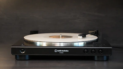 A sleek, modern turntable with a glowing red needle ready to play a record.