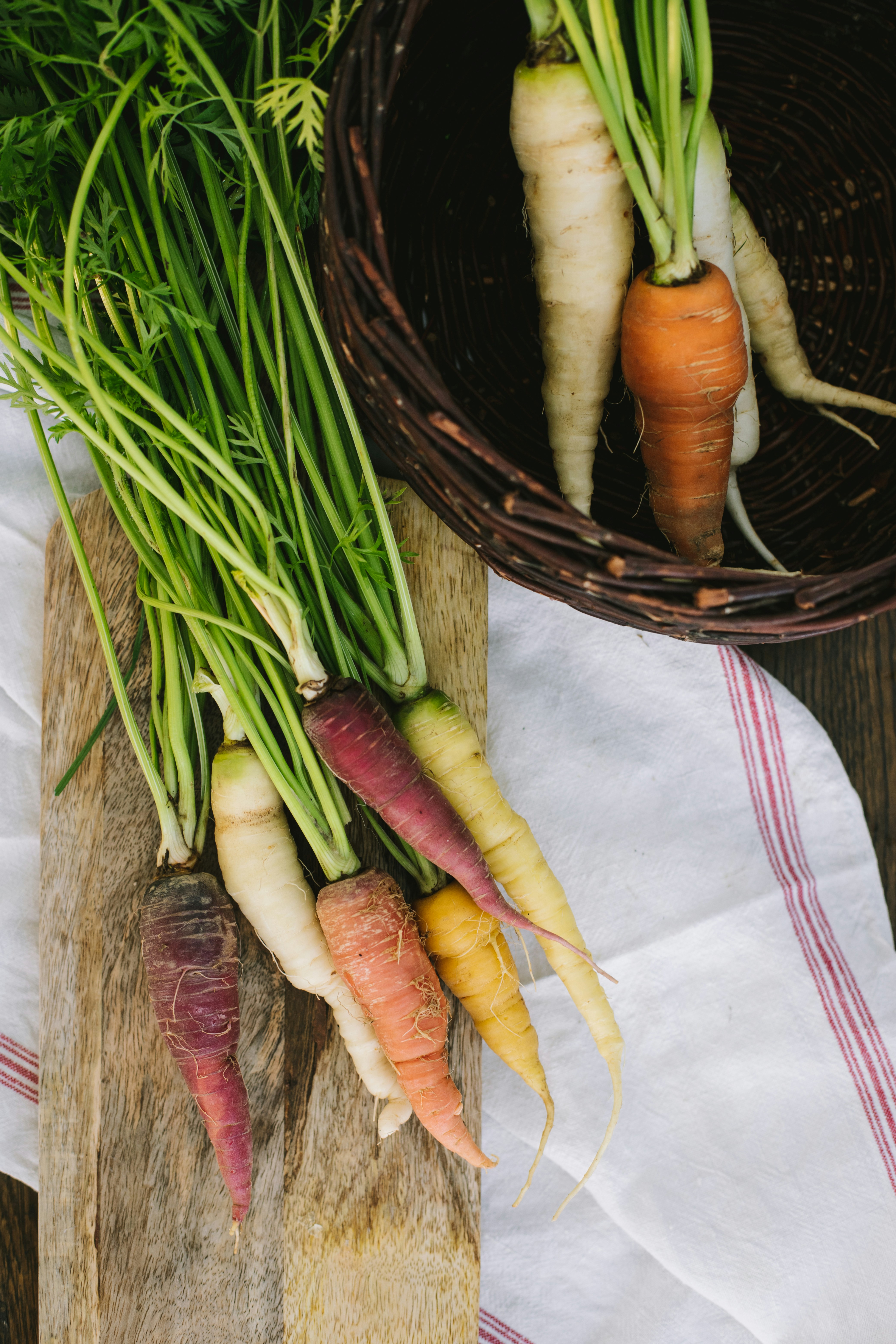 a bunch of carrots sitting on top of a wooden cutting board
