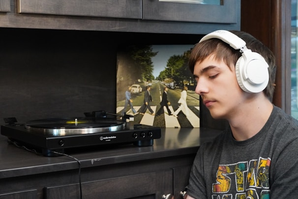 Artist filling out metadata form on a tablet, surrounded by vinyl records and headphones.