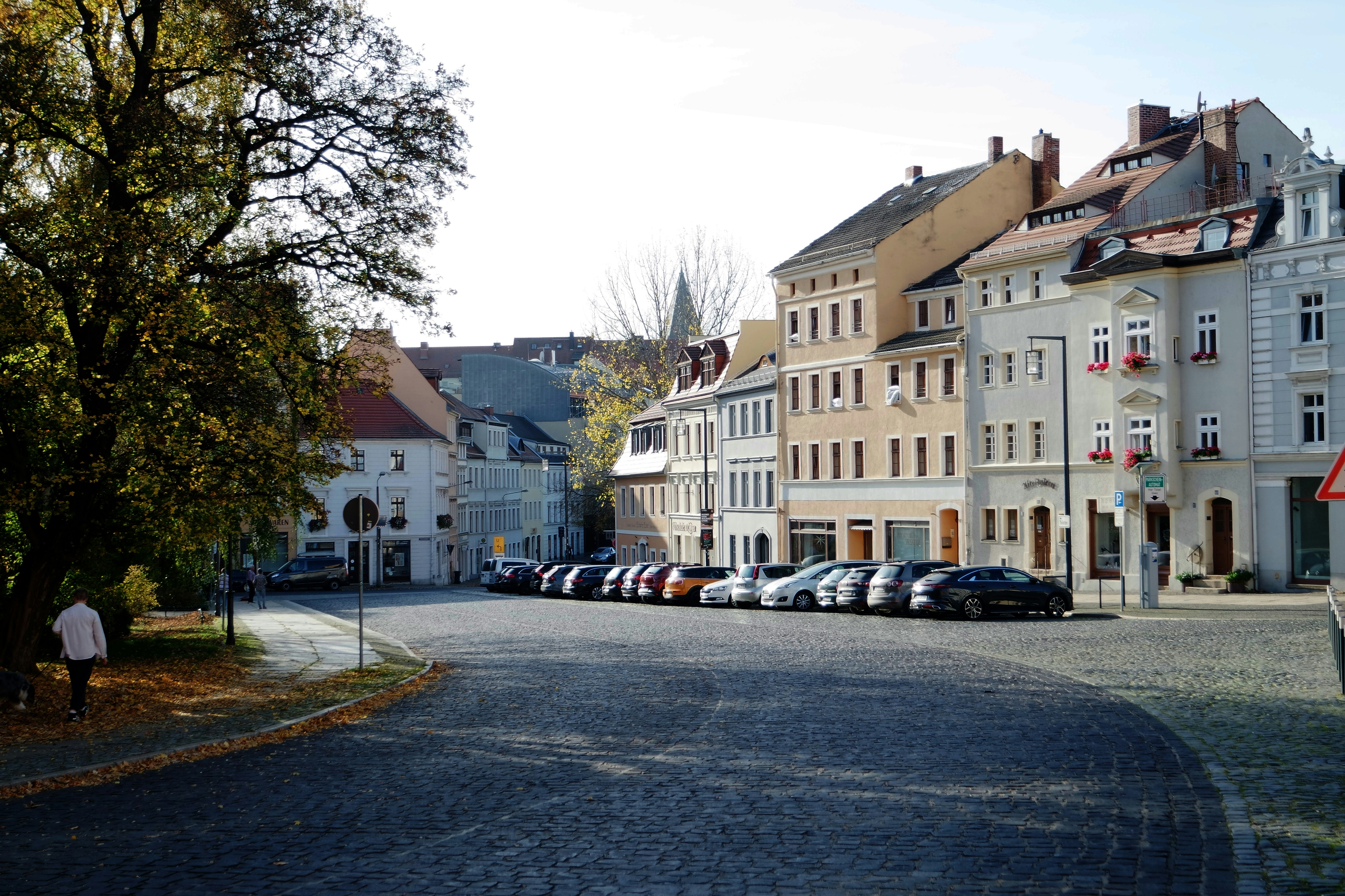 a row of parked cars on a cobblestone street