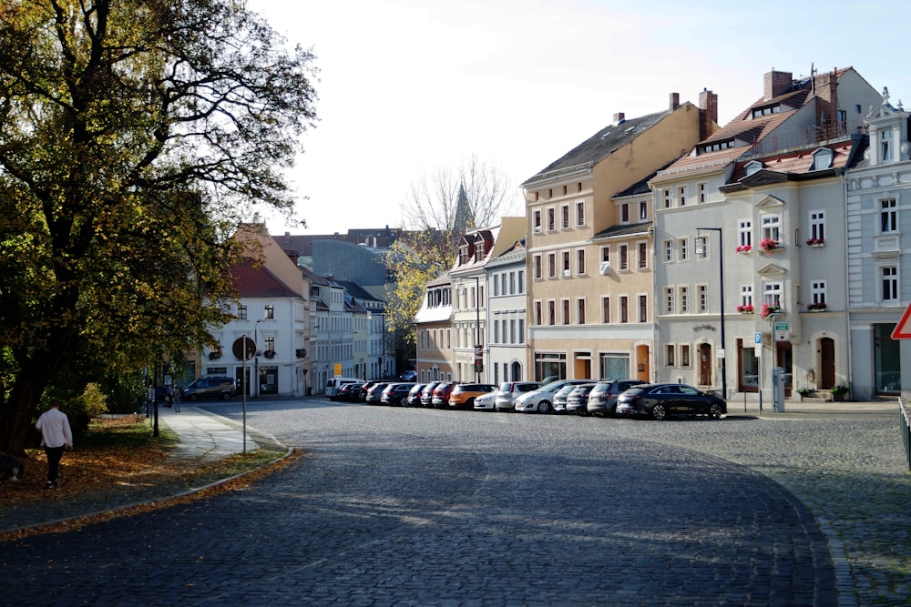 a row of parked cars on a cobblestone street