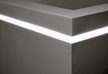 A minimalist room transformed by subtle LED lighting effects.
